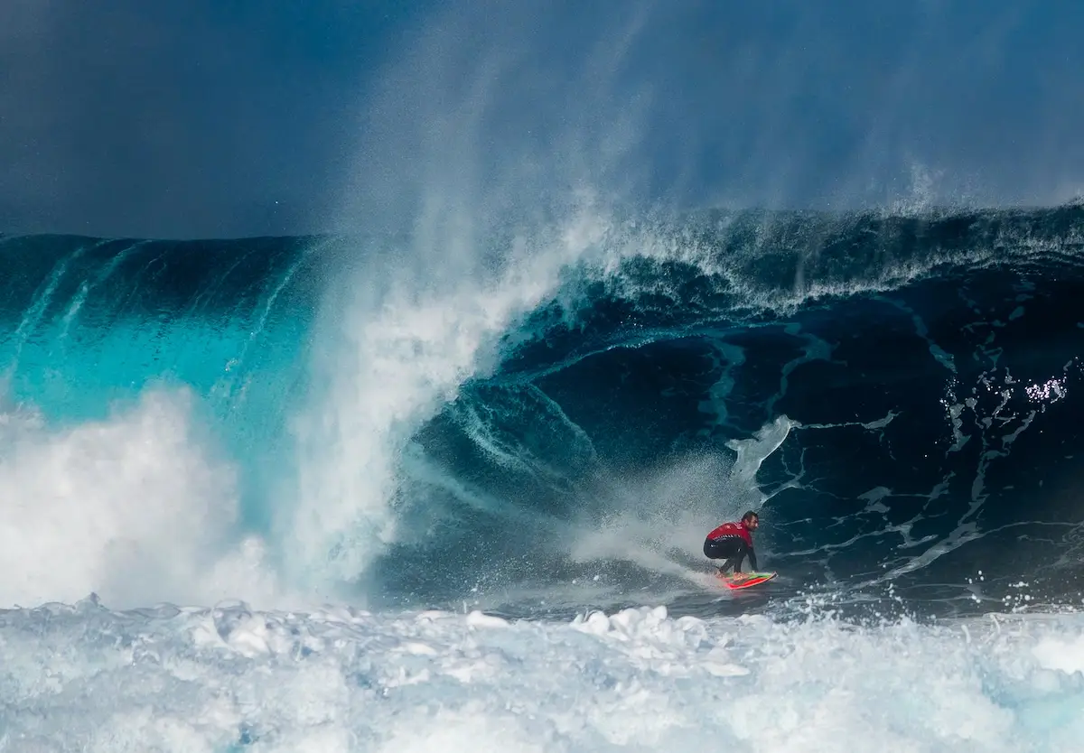 Surfing dude on the waves taken from a drone